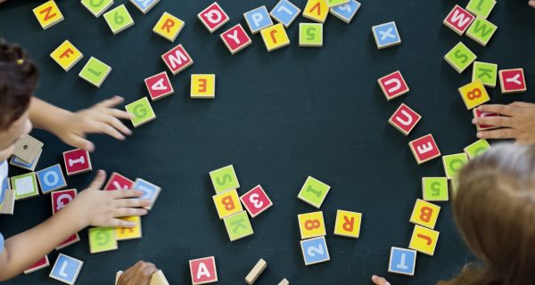 Kindergarten kids playing wooden alphabets letters vocabulary ga